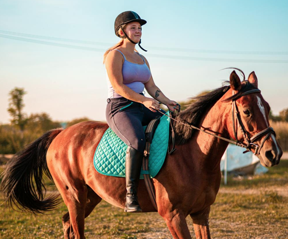 girl riding horse as a part of equine therapy