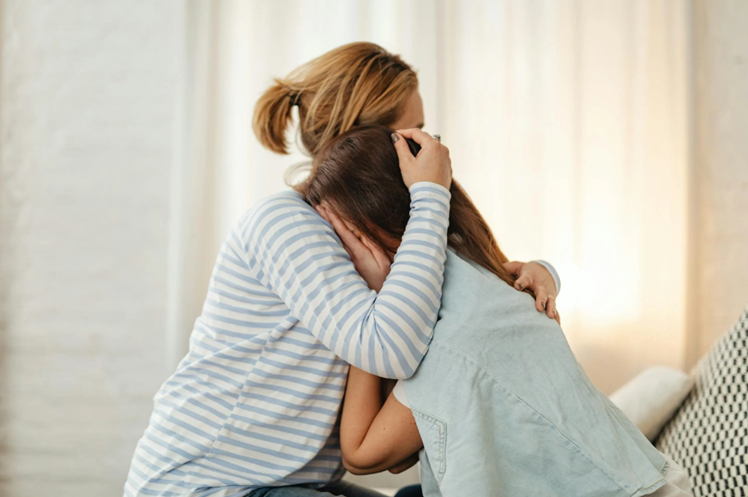 mother hugging her child who is struggling with self harm and teen mental health