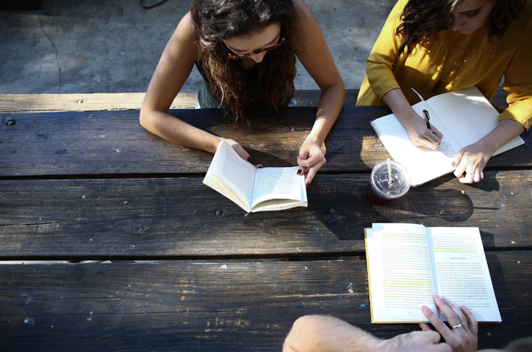 girls sitting at table journaling